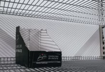 Jak wykorzystać boxy półkowe do promocji sezonowych kolekcji Pusty kartonowy box ekspozycyjny na metalowej półce sklepowej.