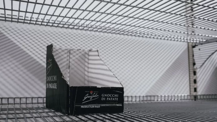 sezonowa-kolekcja-box-polkowy-sklep Pusty kartonowy box ekspozycyjny na metalowej półce sklepowej.